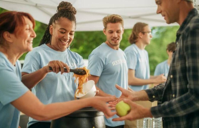 Humanitarian aid charity workers serve meals to people in need